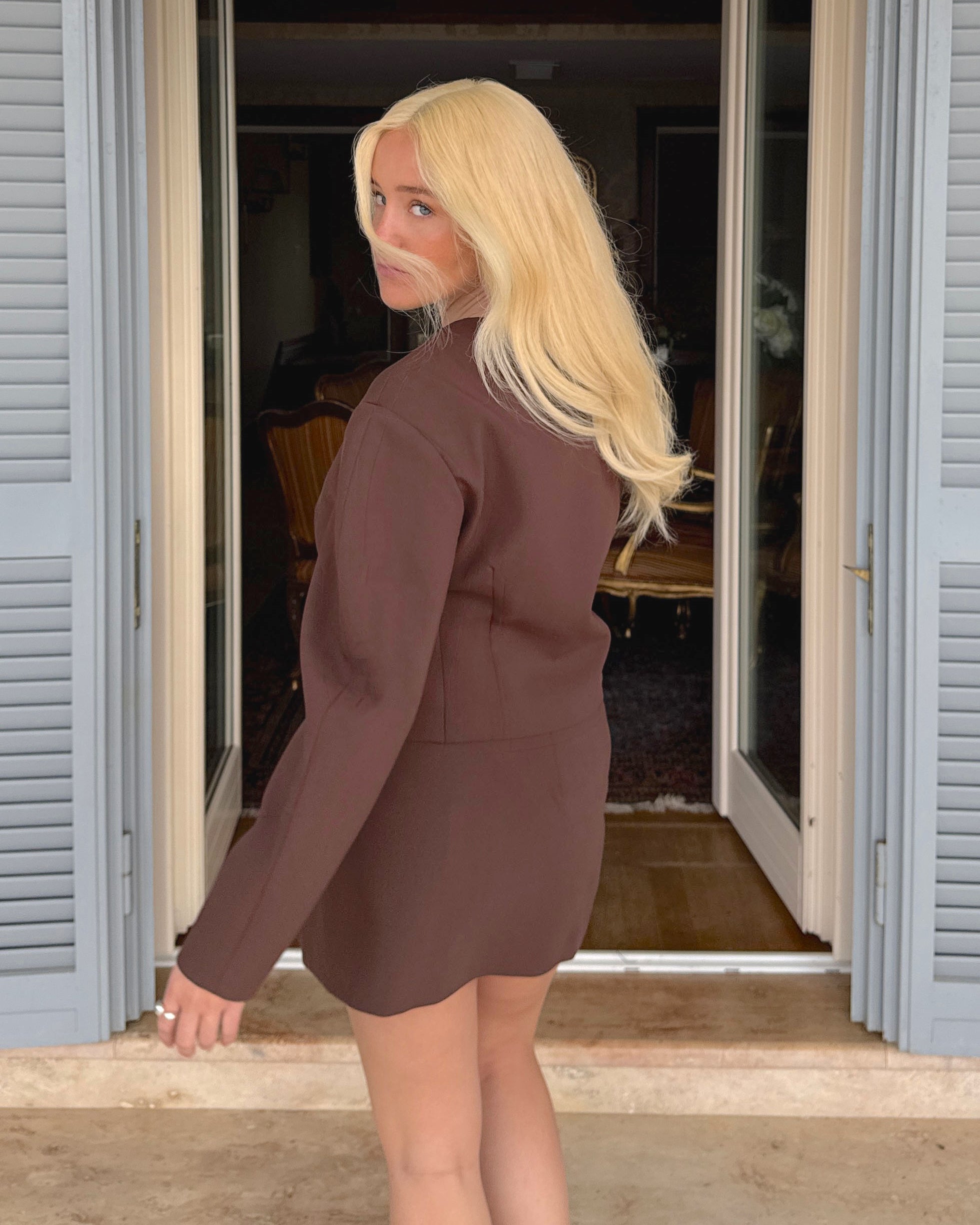 Woman wearing a long BHBD Livia warm blonde wig.