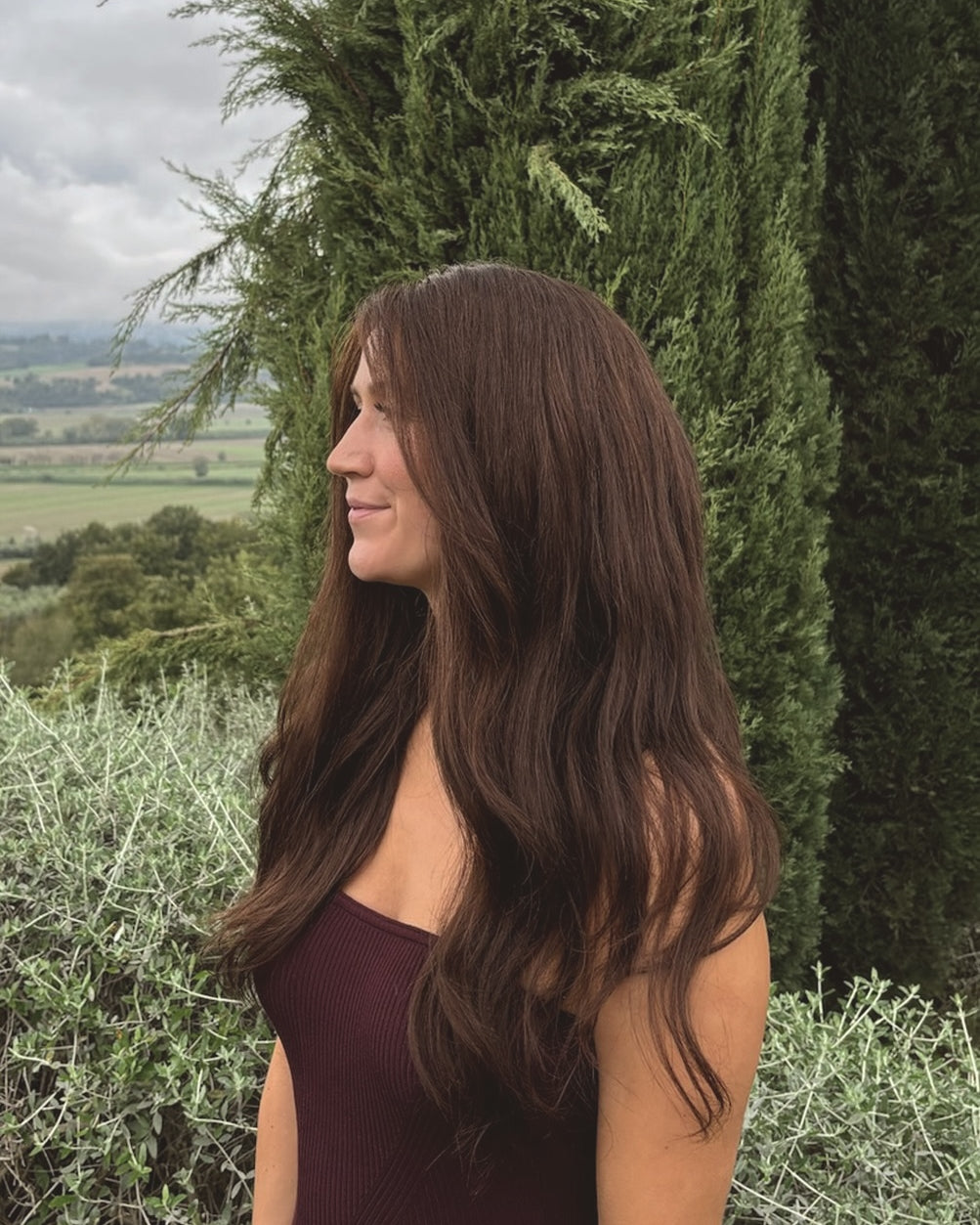 Woman wearing a BHBD Valentina wig. Long natural dark brown wig.