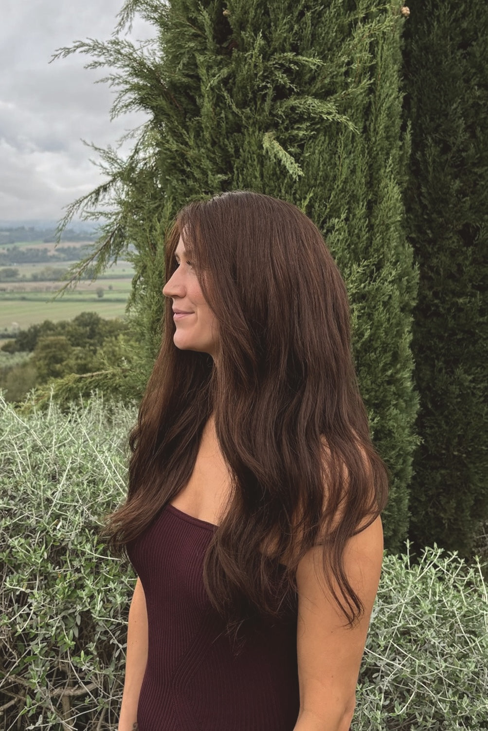 Woman wearing a BHBD Valentina wig. Long natural dark brown wig.